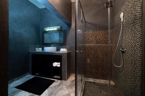 a bathroom with a glass shower and a sink at Riad Ksar Aylan in Ouarzazate