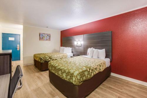 a hotel room with two beds and a red wall at Econo Lodge in Savannah