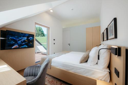 Schlafzimmer mit einem Bett, einem Schreibtisch und einem Fenster in der Unterkunft Spa Suite Dobrna - Terme Dobrna in Dobrna