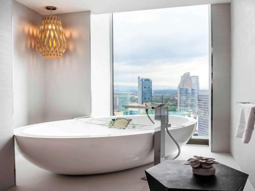 a large white bath tub sitting next to a large window at Sofitel Mexico City Reforma in Mexico City