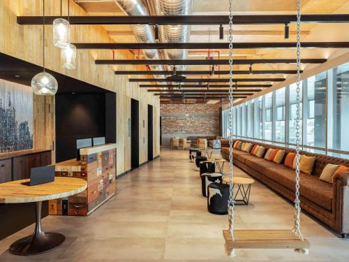 a lobby with a couch and a swing at Novotel Mexico City Toreo in Mexico City
