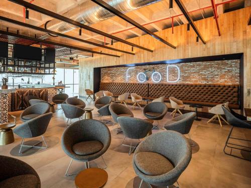 a waiting room with chairs and a bar at Novotel Mexico City Toreo in Mexico City