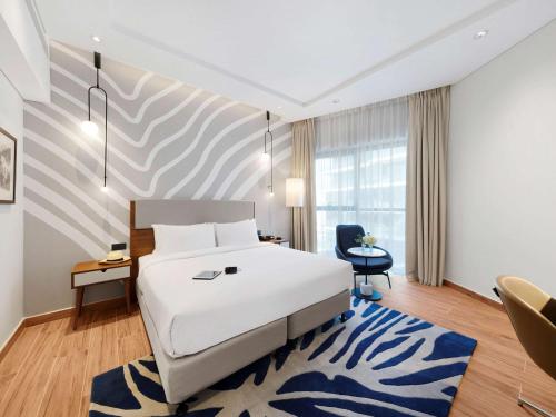 een hotelkamer met een bed en een blauw tapijt bij Adagio Premium The Palm in Dubai