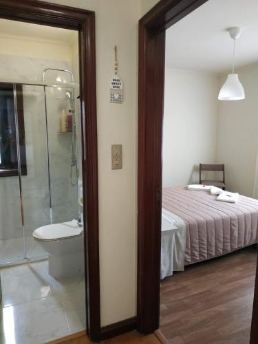 a bedroom with a bed and a shower and a toilet at Casarão Paraíso in Perafita
