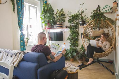 a man and woman sitting on a couch in a living room at La Kanopee - Les Loges Normandes in Cherbourg en Cotentin