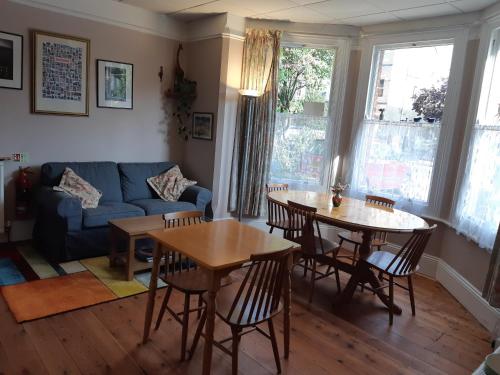 a living room with two tables and a couch at Acorn Guest House in Oxford