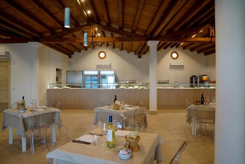 GH Santina Resort & SPA في فاليدوريا: غرفة كبيرة بها طاولات وكراسي ومطبخ