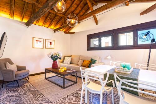 uma sala de estar com um sofá e uma mesa em Genteel Home Zacatín em Granada