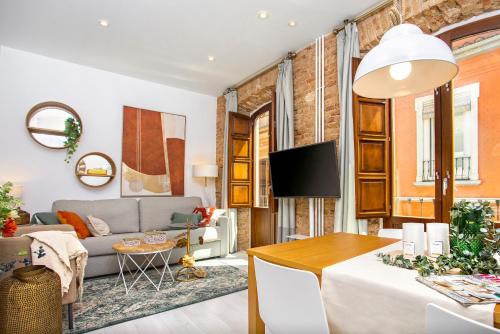 uma sala de estar com um sofá e uma mesa em Genteel Home Zacatín em Granada