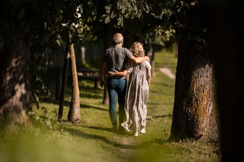 a man and woman walking down a path in a park at Hotel Gasthaus Post in Campo di Trens
