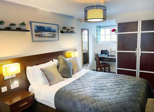 a bedroom with a large bed and a desk with a desk at The High Flyer in Ely