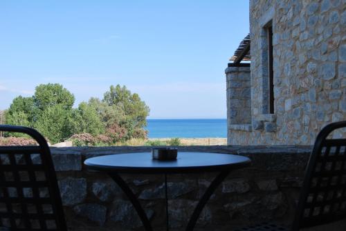 a table and chairs on a patio with a view of the ocean at Castello Antico Hotel in Gythio