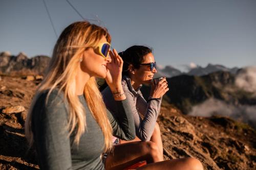 two people sitting on top of a mountain at Hotel Gasthaus Post in Campo di Trens