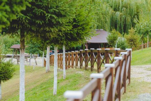 a wooden fence with trees in front of a building at Hotel Class in Brezoi