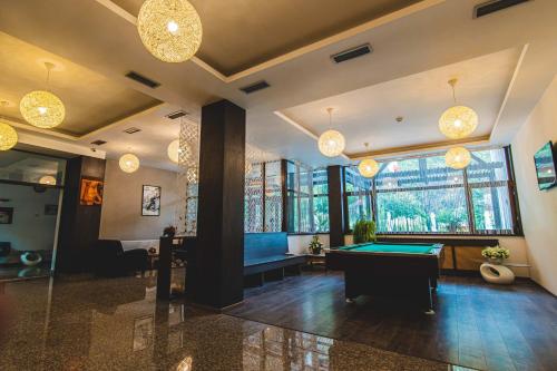 a billiard room with a pool table and chandeliers at Hotel Class in Brezoi