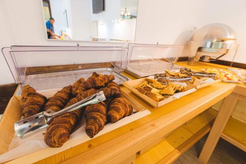a table with a bunch of pastries and other foods at Hotel Class in Brezoi
