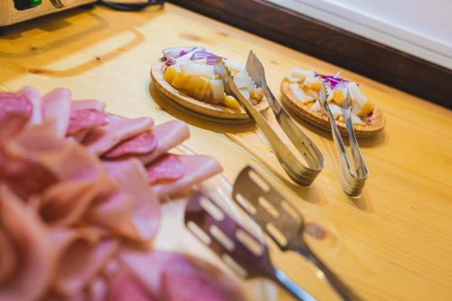 two pizzas on a table with forks and knives at Hotel Class in Brezoi