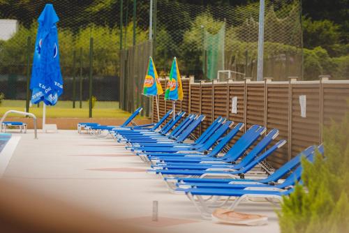 a row of blue beach chairs with umbrellas at Hotel Class in Brezoi