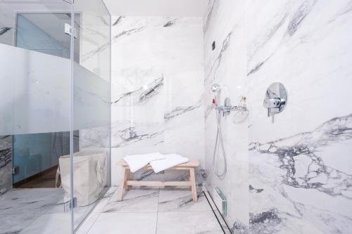 a bathroom with a shower with a bench in it at Spa Suite Dobrna - Terme Dobrna in Dobrna