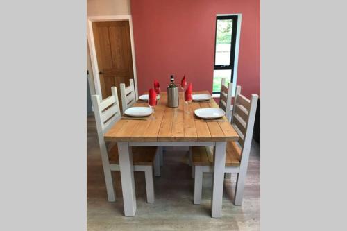 a wooden table with chairs around it in a room at Delightful detached Cottage in Village Centre in Plymtree