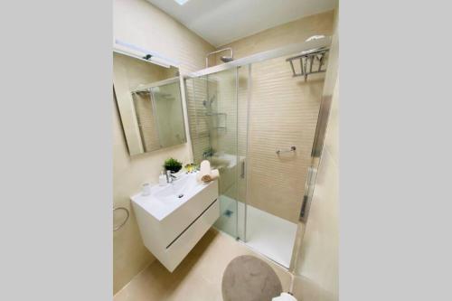 a bathroom with a glass shower and a sink at Bungalow Dunaflor Verde 4 in San Bartolomé