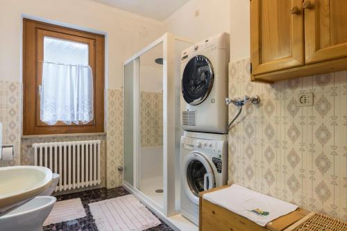 a bathroom with a washing machine and a sink at Casa al sole in Bresimo