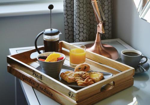 a wooden tray with breakfast food on a table at Formby Hall Golf Resort & Spa in Southport