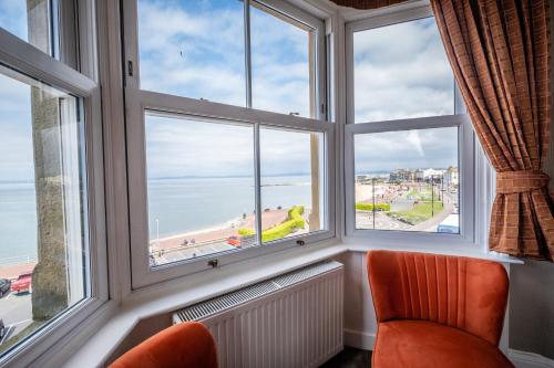 a room with windows with a view of the ocean at The Crown Hotel in Morecambe