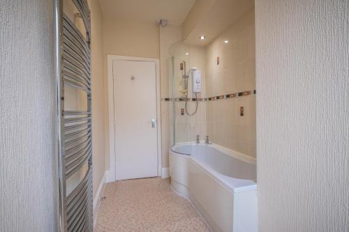 a white bathroom with a tub and a sink at The Crown Hotel in Morecambe