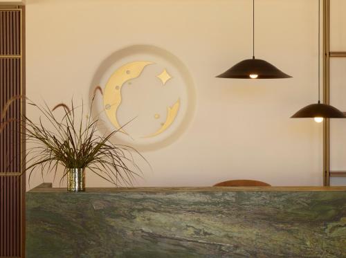 a clock on a wall with a vase with a plant at Asterion Suites & Spa - Designed for Adults in Gerani Chanion