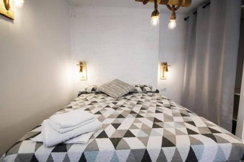 a bedroom with a checkered bed with towels on it at Vivienda con fines turísticos Lagarto de Jaen B in Jaén