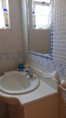 ein Badezimmer mit Waschbecken und Spiegel in der Unterkunft Casa da Zi in Vila Nova de Milfontes