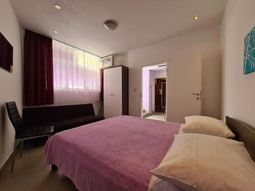 a bedroom with a bed and a chair and a window at Apartment Rabac 2127 in Rabac