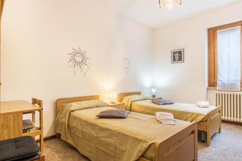 a bedroom with two beds and a window at Casa al sole in Bresimo