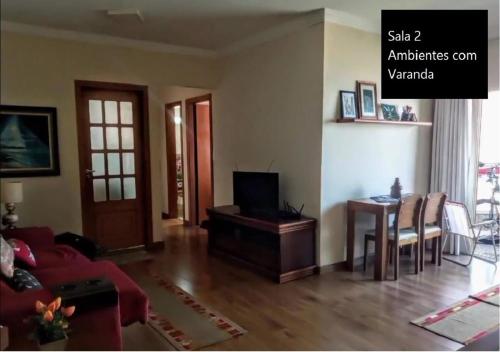 a living room with a couch and a table at Mongaguá - Pé na Areia - 2 Quartos - 6 pessoas in Mongaguá