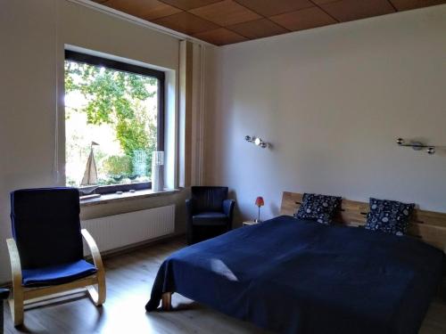 エッカーンフェルデにあるRieger FW 1のベッドルーム1室(ベッド1台、椅子2脚、窓付)