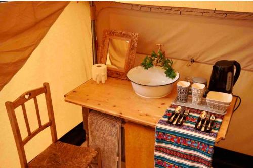 a table in a tent with a sink and a mirror at The Jungle Tent in Carbis Bay