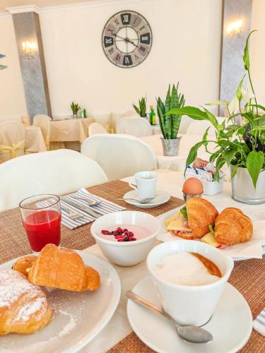 une table avec des assiettes de petit-déjeuner dessus dans l'établissement Hotel Explorer, à Cervia