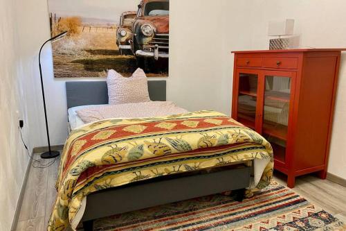 ein Schlafzimmer mit einem Bett und einem Gemälde eines Trucks in der Unterkunft Das Nest, wo der Name Programm ist in Dahlem