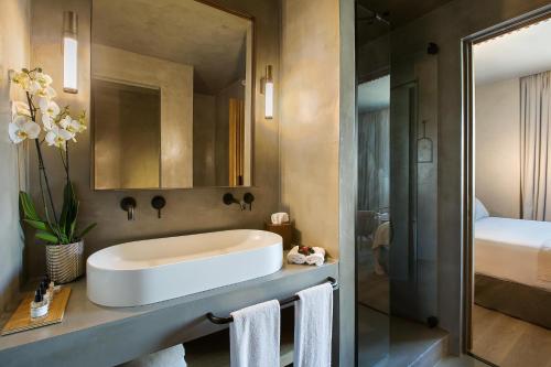 a bathroom with a white sink and a bed at Only YOU Hotel Málaga in Málaga