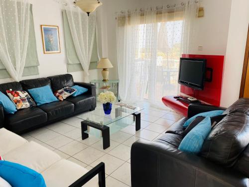 a living room with two couches and a tv at Villa Emiliana in Paralimni