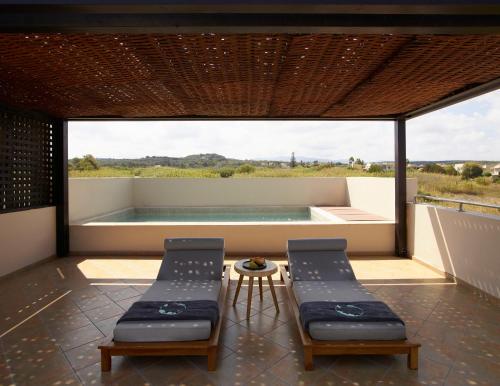 a room with two chairs and a swimming pool at Asterion Suites & Spa - Designed for Adults in Gerani Chanion