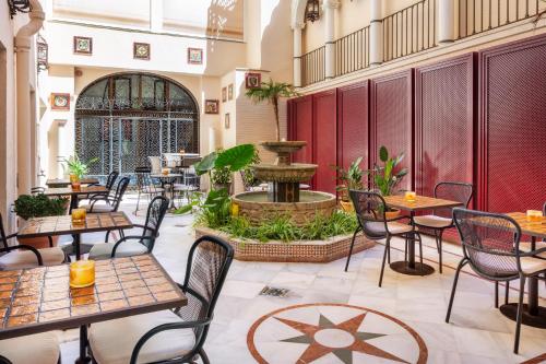 un restaurante con mesas, sillas y una fuente en H10 Corregidor Boutique Hotel, en Sevilla