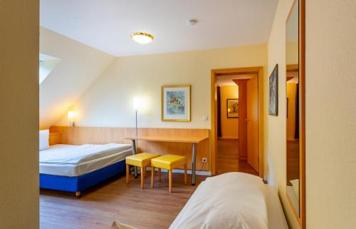a hotel room with two beds and a desk at Waldhotel Eskeshof in Wuppertal