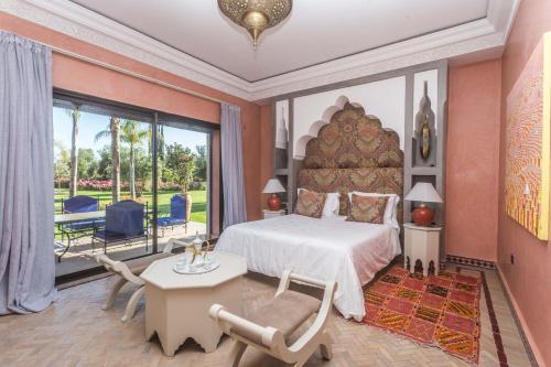 a bedroom with a large bed and a table and chairs at La Villa Rose Anna in Marrakesh