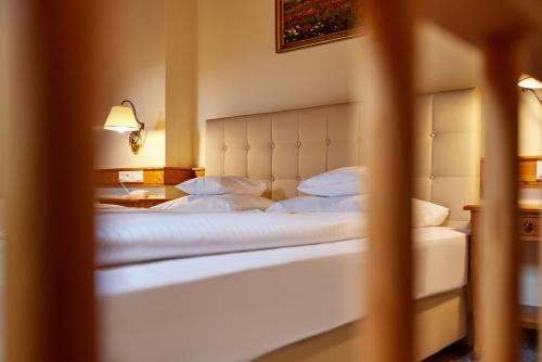 a bedroom with a large bed with white pillows at Hotel Zugspitze in Garmisch-Partenkirchen
