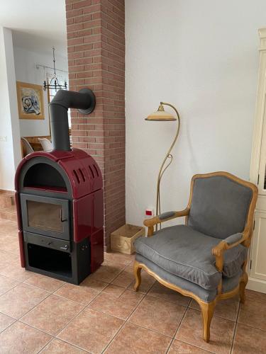 a chair and a wood stove in a room at Ferienhof am Trift in Bad Saarow