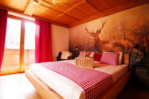 Dormitorio con cama con ciervo en la pared en Haus Waldruhe, en Mallnitz