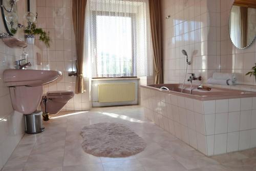 ein Badezimmer mit einem Waschbecken, einer Badewanne und einem WC in der Unterkunft Ferienhaus AM ALTEN POSTHOF in Lieser