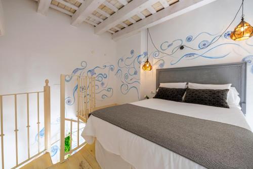 um quarto com uma cama e uma parede com um mural em La Casa de la Favorita em Tarifa